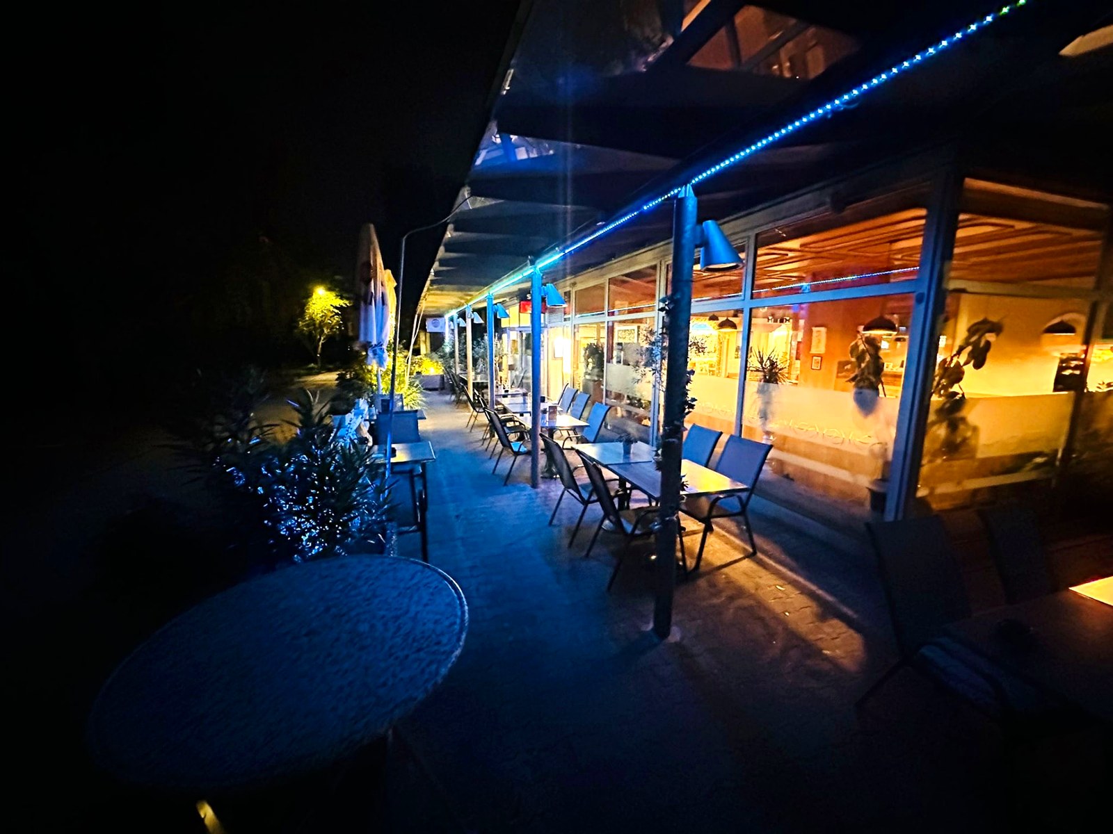 Beleuchtete Terrasse des Restaurant Olympos am Abend