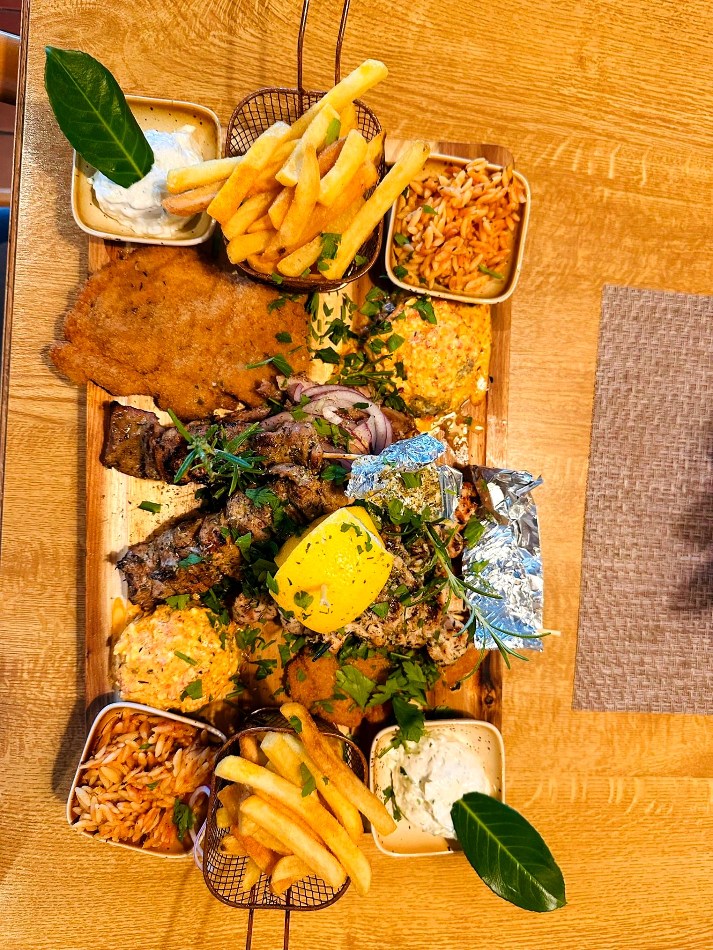 Grillplatte mit Souvlaki, Gyros, Tzatziki und griechischen Nudeln im Restaurant Olympos